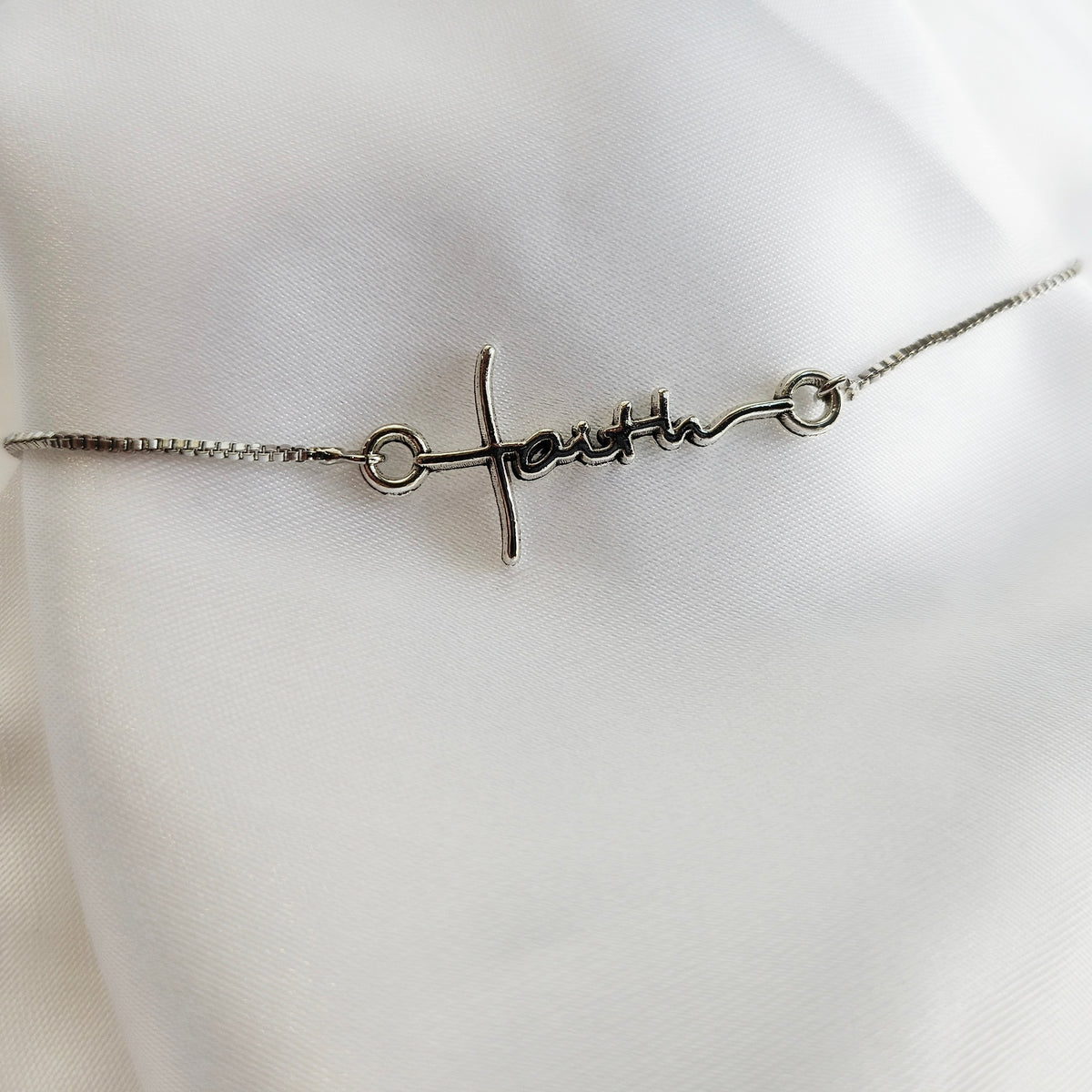 Silver bracelet with &#39;Happy&#39; engraved on a white mannequin.