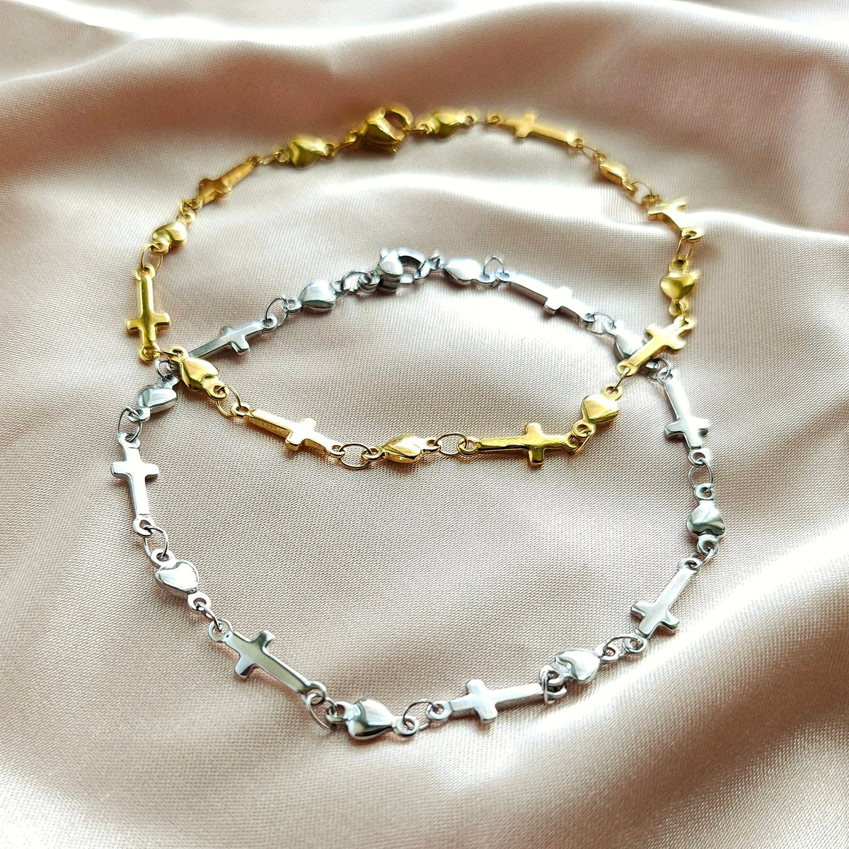 Two gold and silver bracelets on a beige fabric background